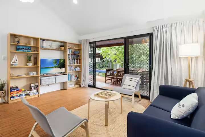 The Breezeway lounge with blue sofa and sliding doors open to the deck